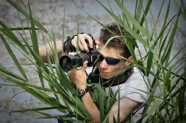 Hrvoje Krhac taking witha camera in shrubbery